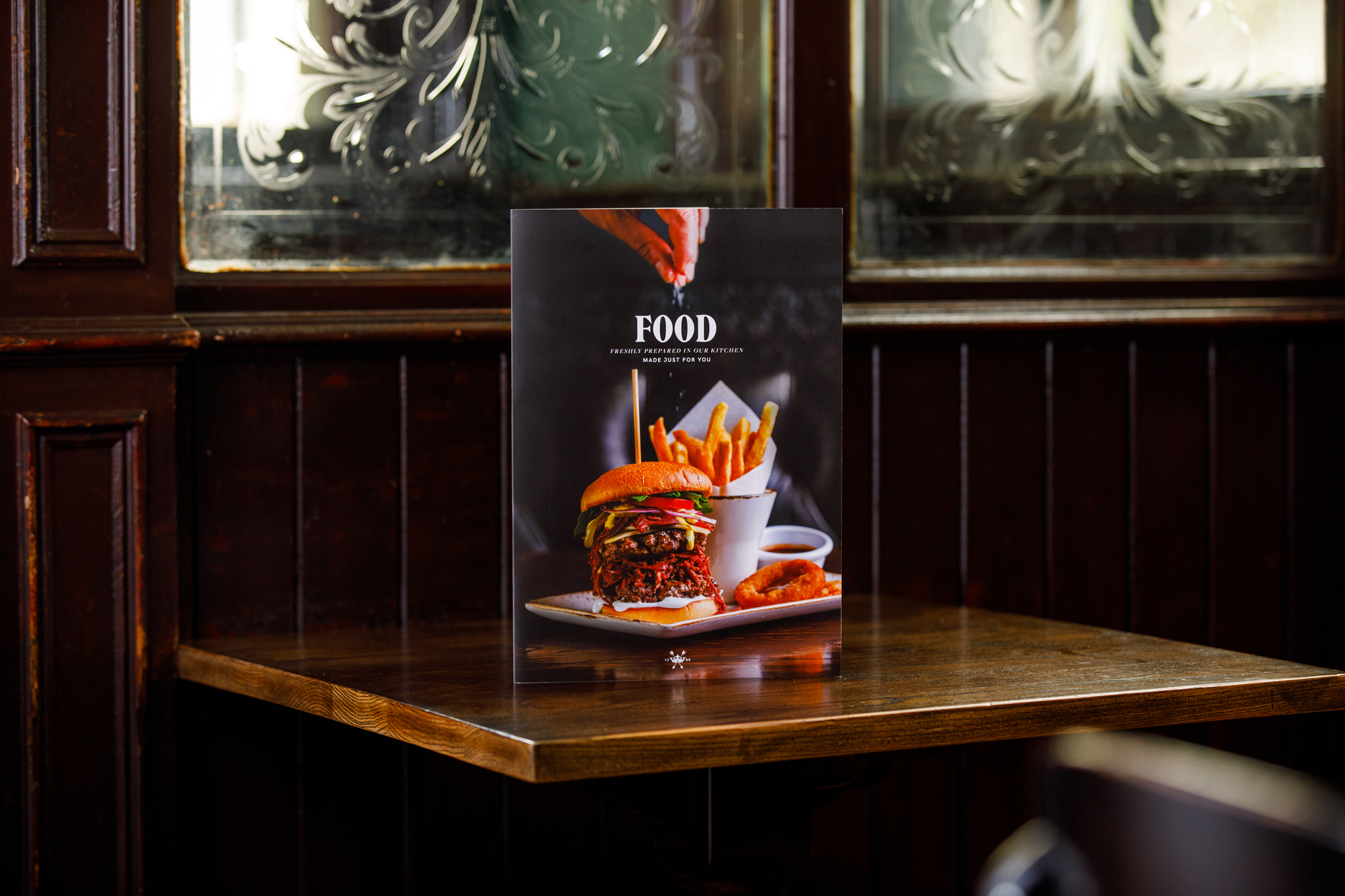 photo of a pub food menu in an old wood panelled pub with etched glass partitions