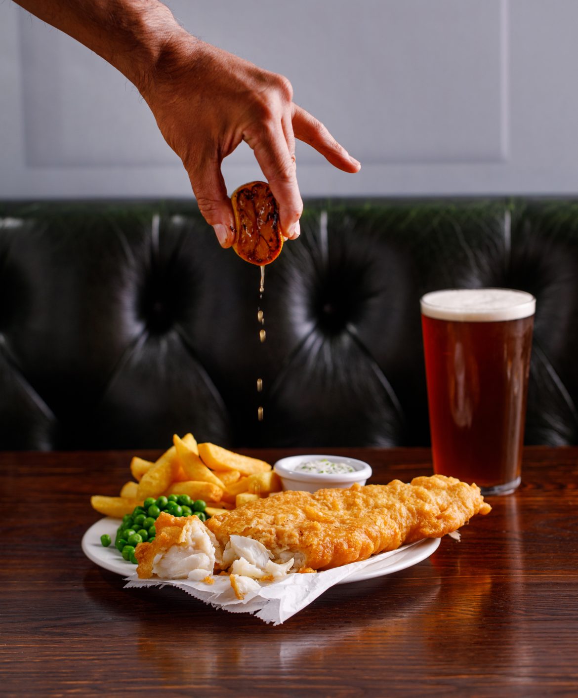photo of fish and chips with lemon being squeezed over the top