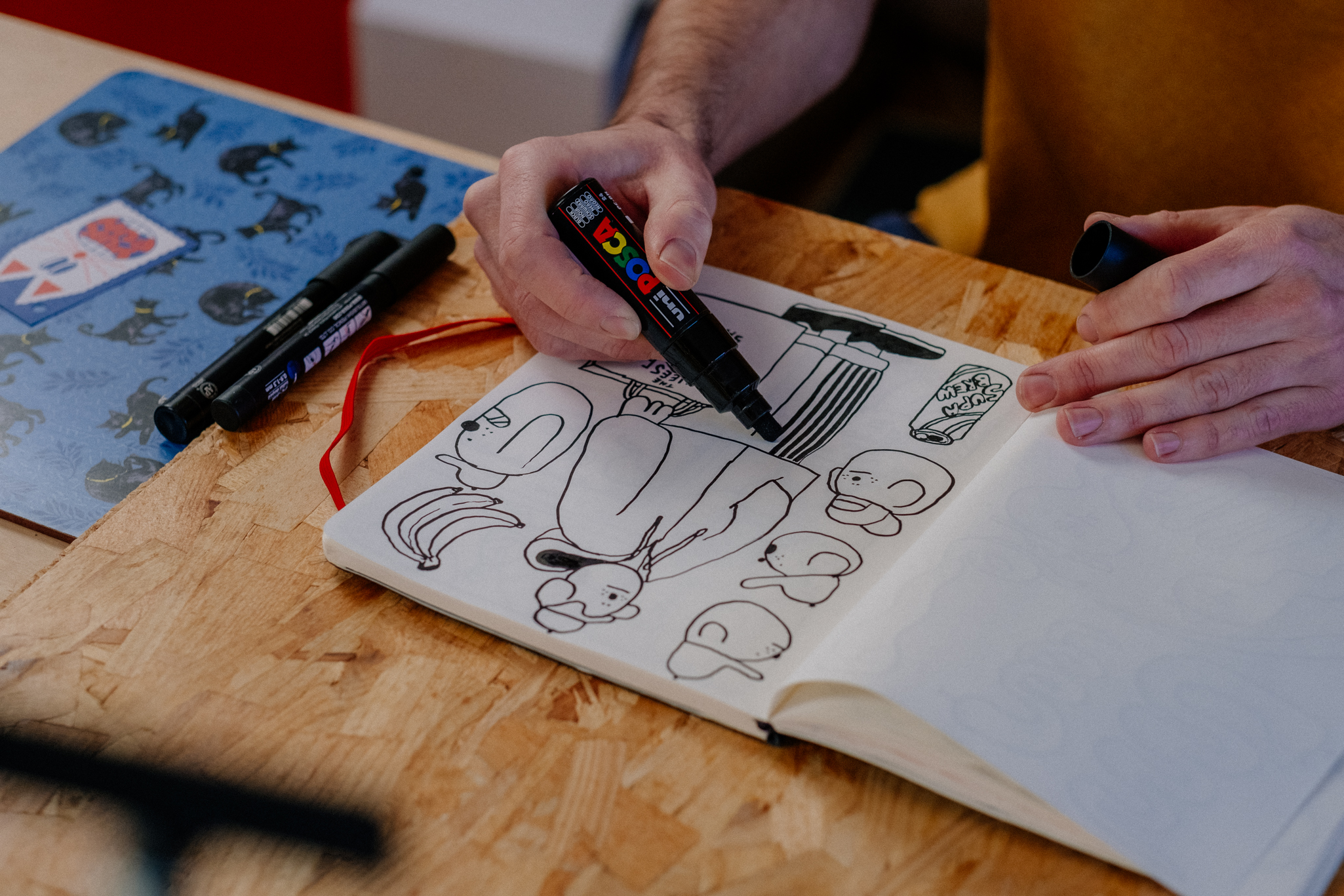 close up photograph of an artist drawing in sketchbook with market pens