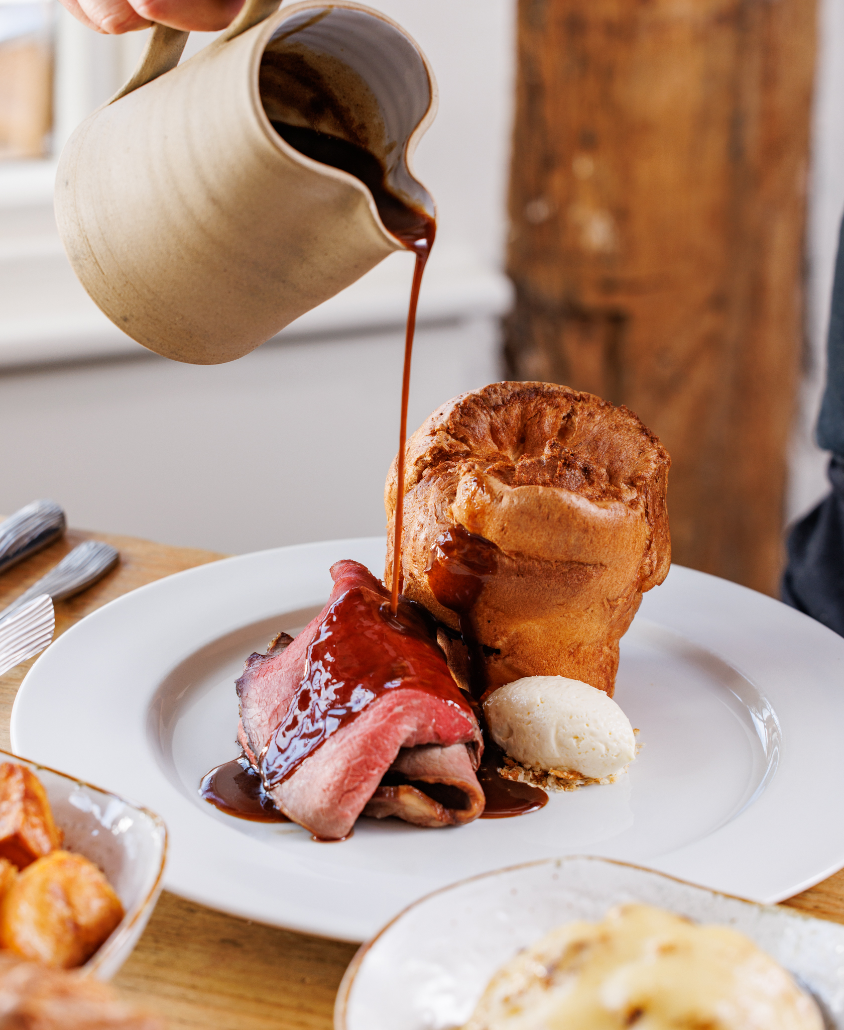 Roast beef with Yorkshire pudding and gravy being poured, plated for Sunday lunch at The Mount gastropub in Henley-in-Arden.