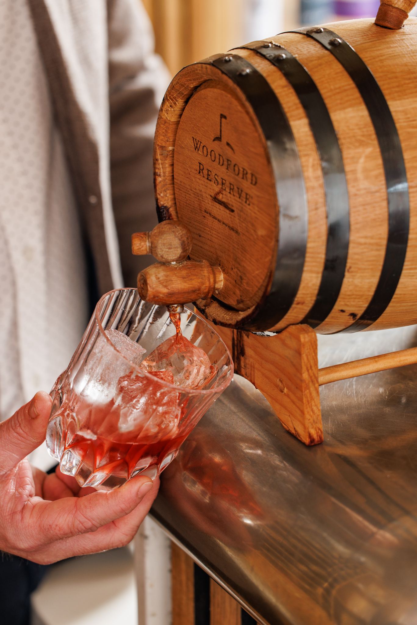 Barrel-aged cocktail being poured over ice from a mini Woodford Reserve barrel into a glass at The Mount gastropub.