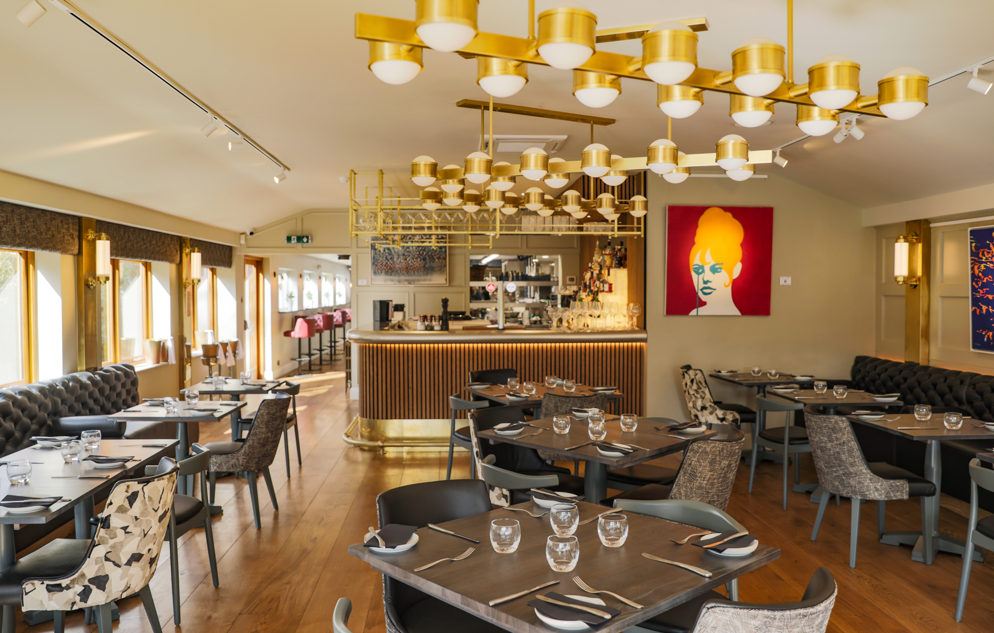 Bright, modern dining area at The Mount with gold lighting, elegant decor, and neatly set tables ready for service.