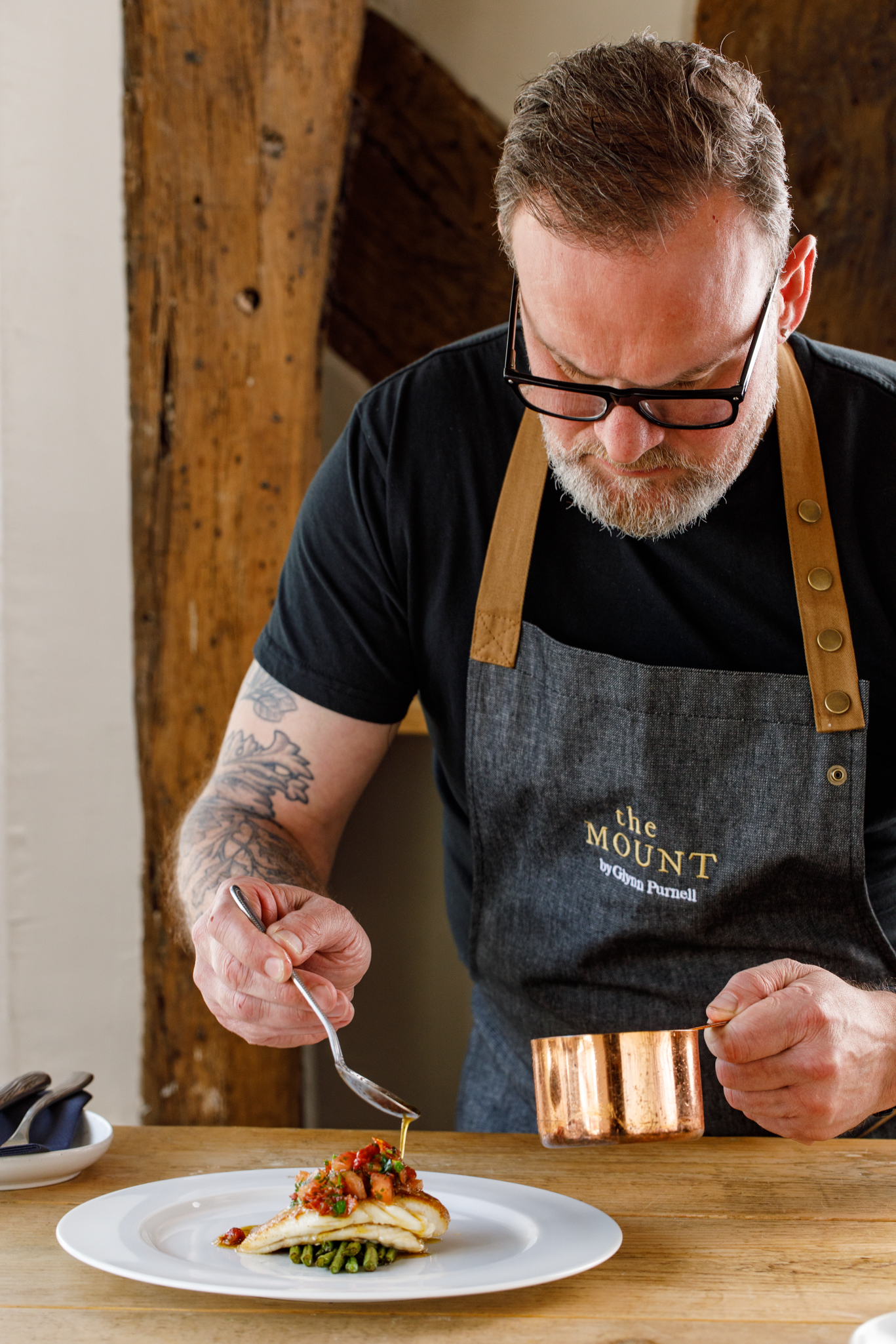 Chef Glynn Purnell plating a fish dish at The Mount gastropub, captured mid-service in a behind-the-scenes restaurant photography shot